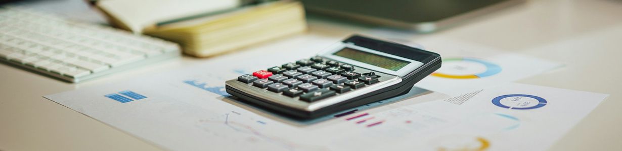 Tisch mit Taschenrechner und Papieren